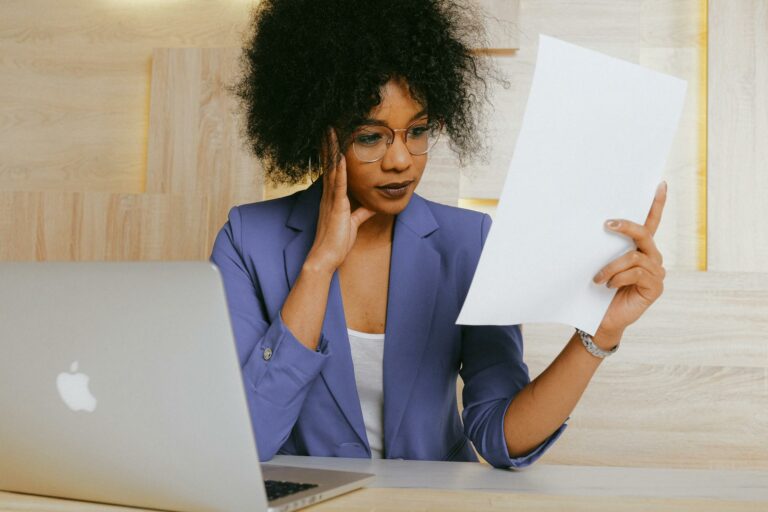 woman in blue blazer holding white paper